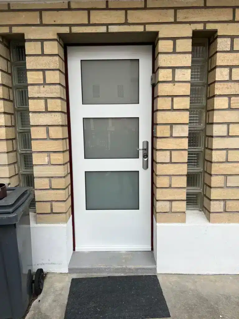 Porte d'entrée blanche de maison en pierre meulière, vue de l'extérieur