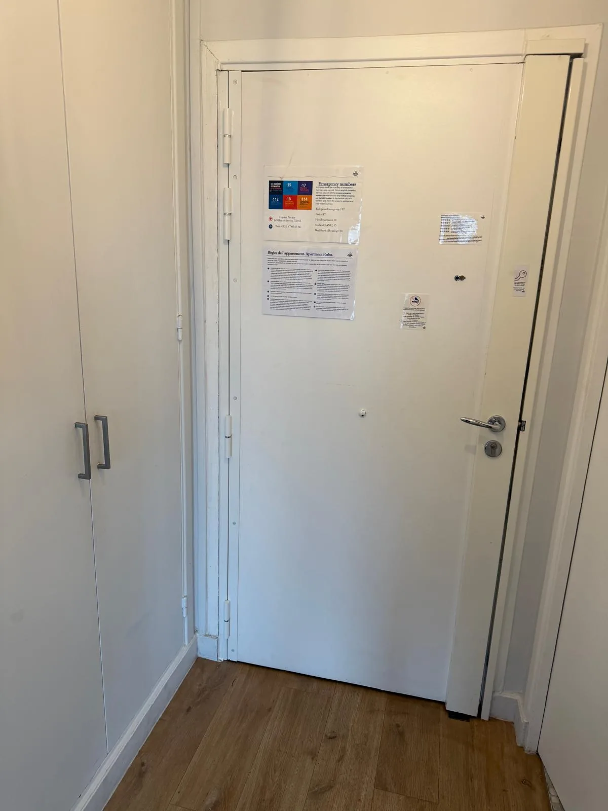 Porte blindée blanche posée dans l'entrée d'un appartement, vue de l'intérieur, étiquette de certification collée sur le vantail
