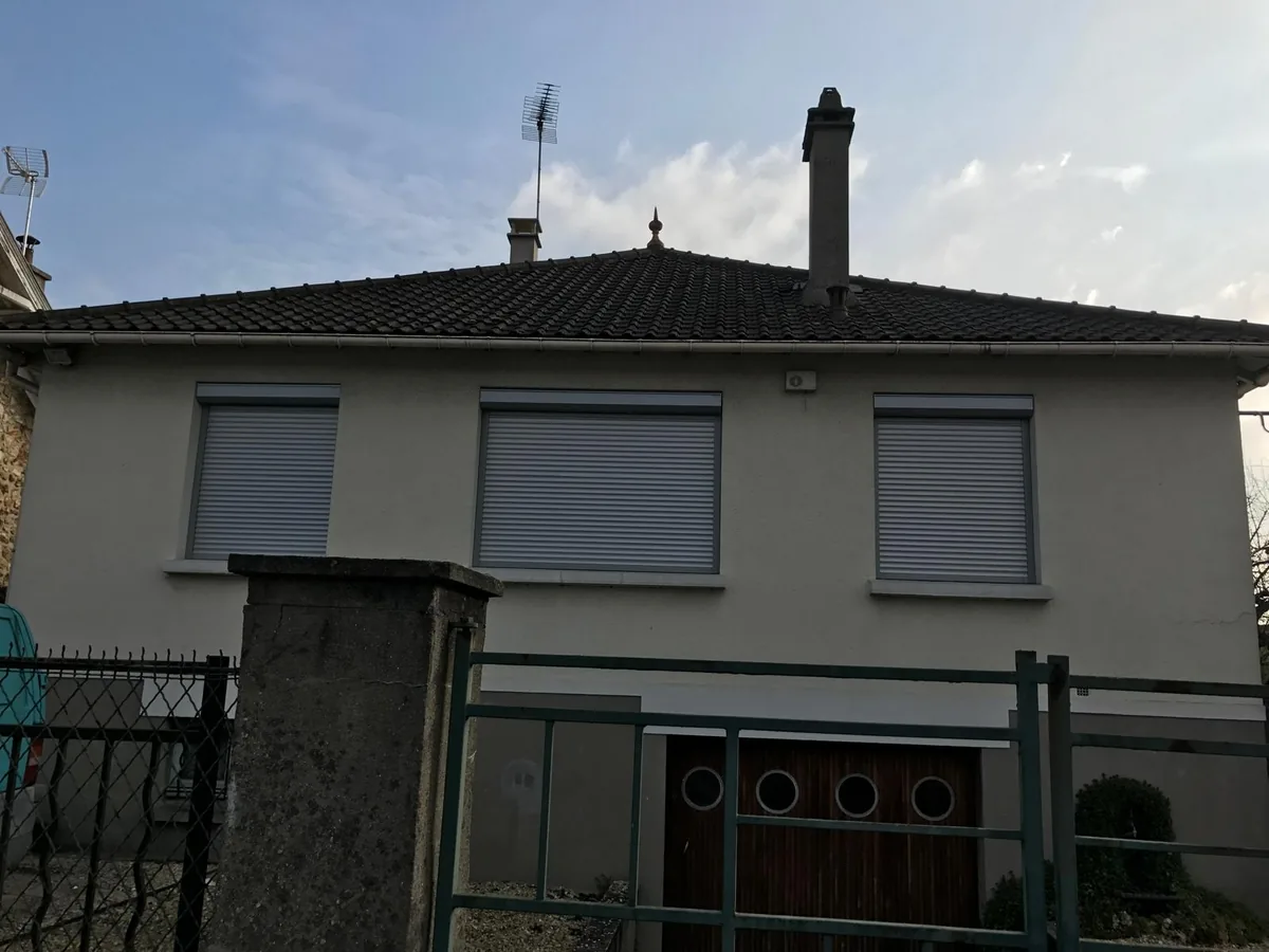 Maison équipée de volets roulants gris neufs, vue depuis le portail