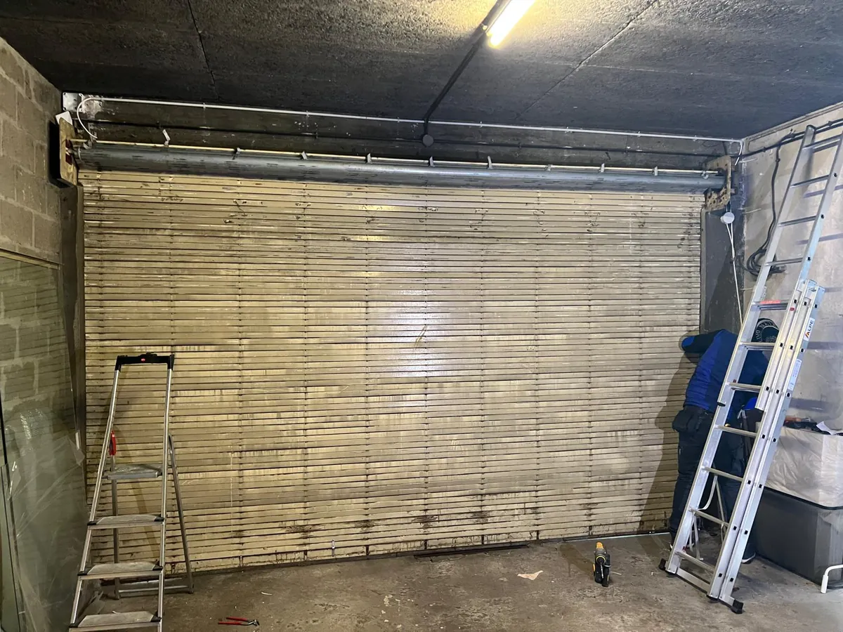 Rideau métallique de local commercial équipé d'un axe motorisé, chantier en cours