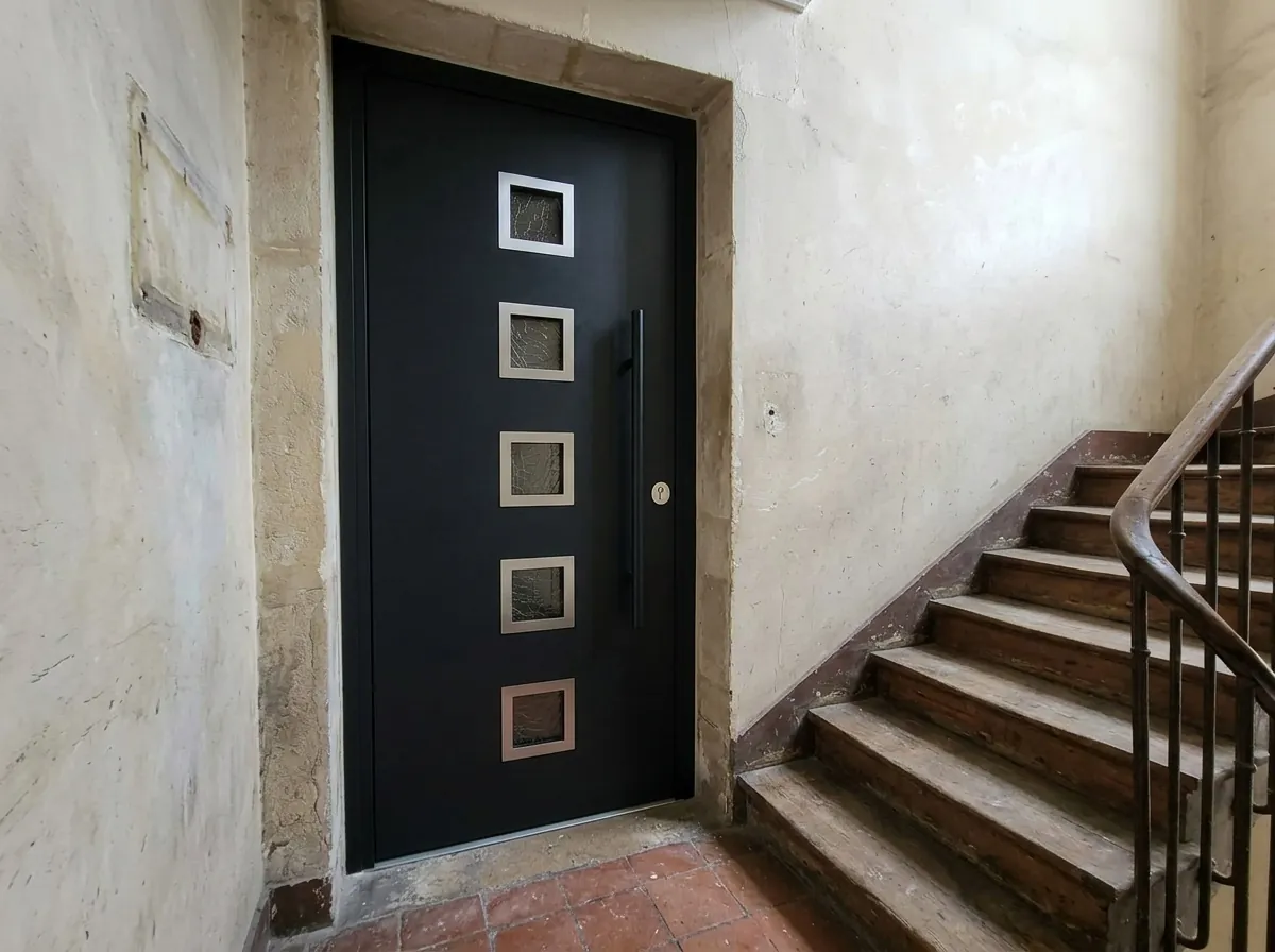 Porte blindée vitrée sur le palier d'un immeuble ancien