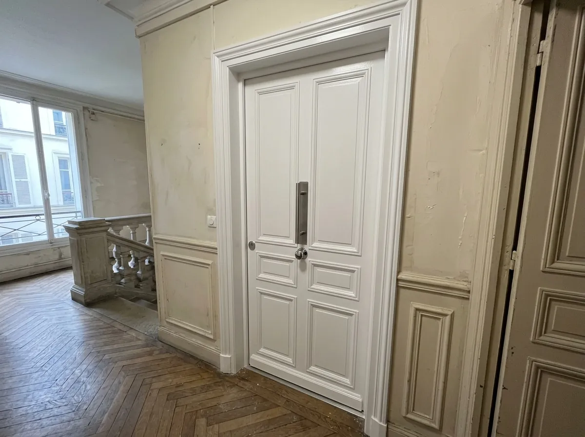 Renforcement de porte bois par tôle acier sur le palier d'un immeuble haussmannien