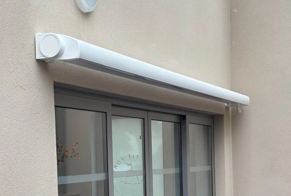 Coffre de store banne sur mesure fixé au-dessus d'une baie vitrée coulissante