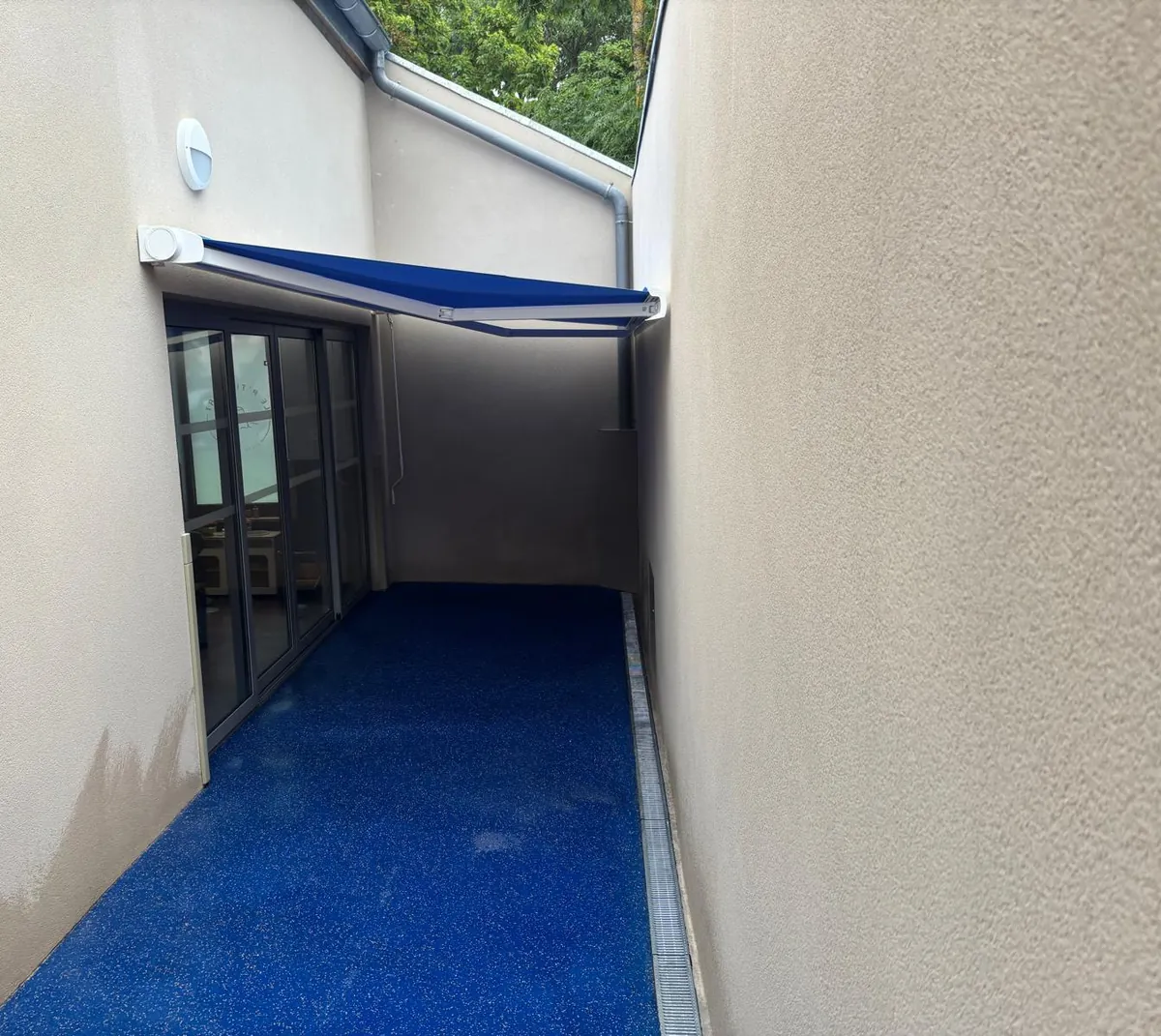 Store banne bleu posé au-dessus d'un balcon étroit d'appartement