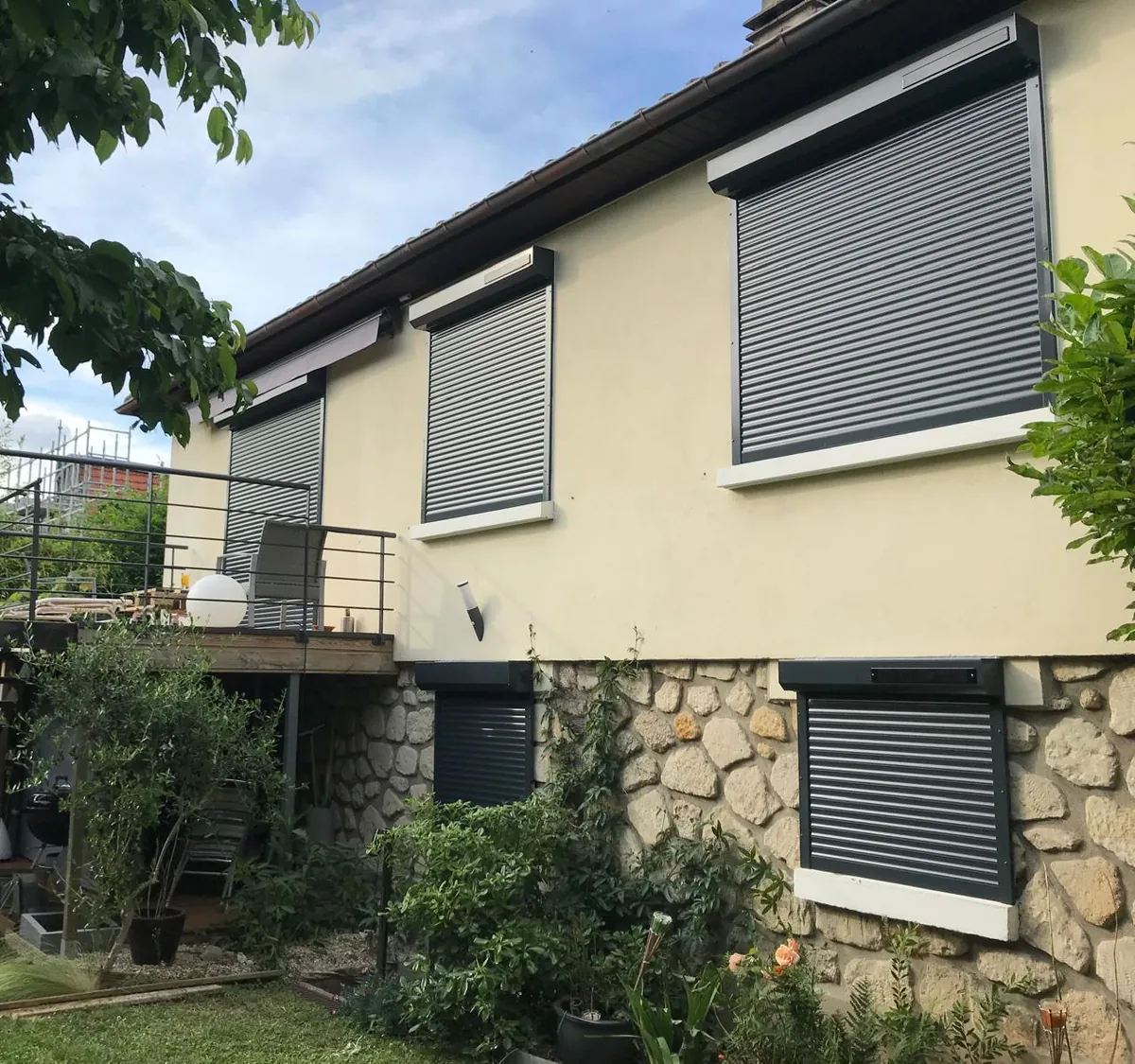 Volets roulants de rénovation posés sur une maison en meulière avec jardin