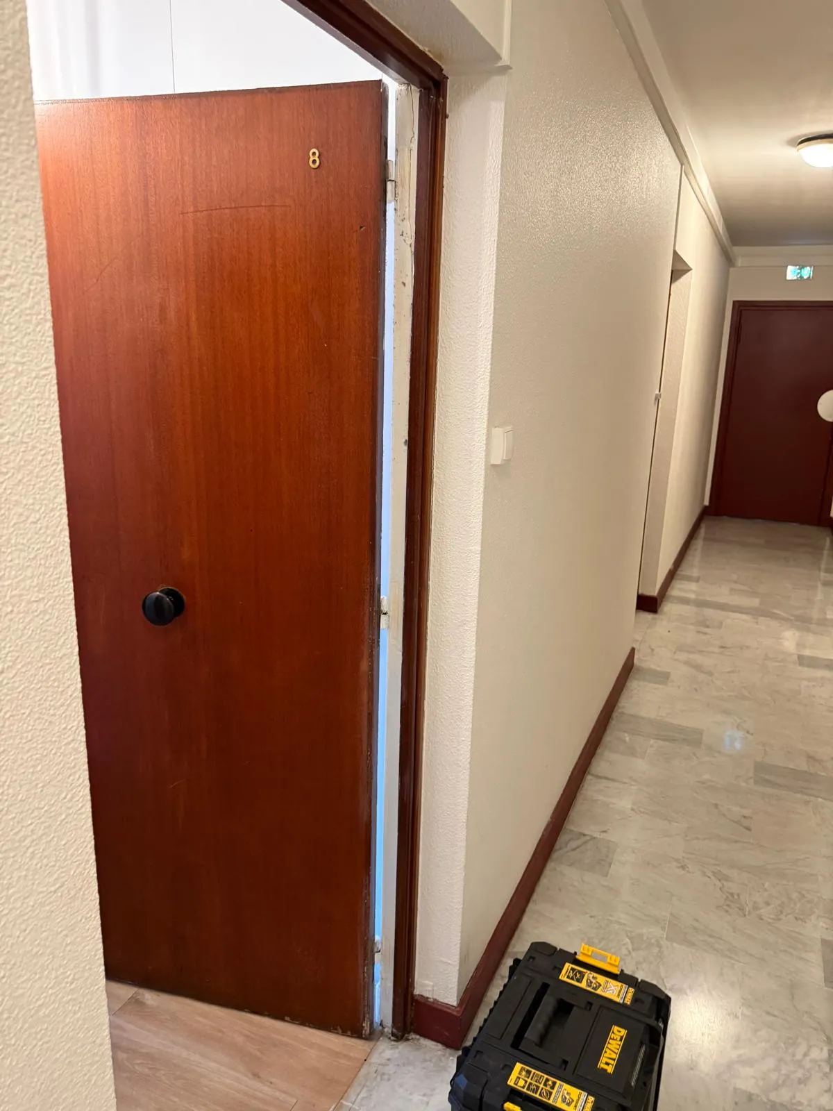 Ancienne porte palière en bois dans un couloir d'immeuble, avant blindage