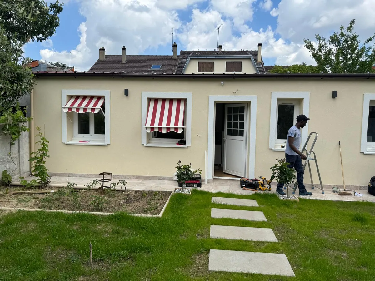 Maison de plain-pied avec stores corbeille rayés rouge et blanc aux fenêtres