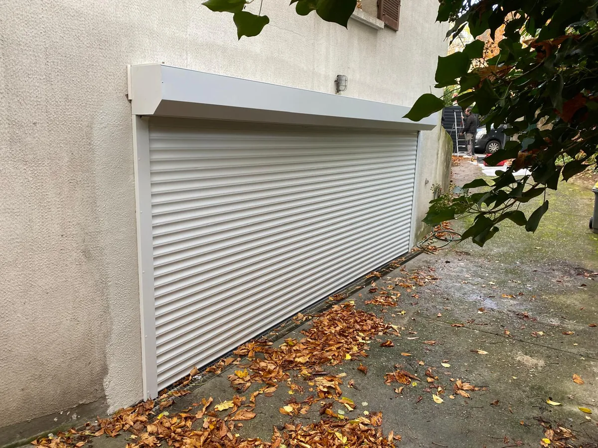 Porte de garage enroulable blanche avec coffre, garage en sous-sol de maison