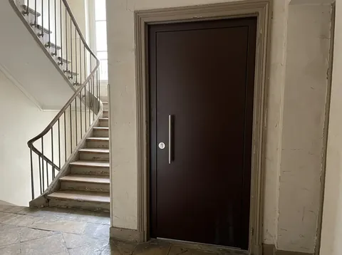Renforcement de porte bois par tôle acier sur le palier d'un immeuble ancien